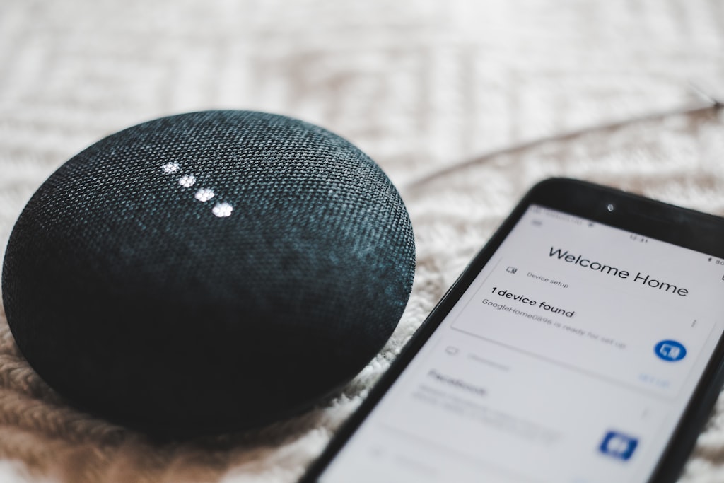 Caixas de som Google Home ainda não entram na primeira etapa da troca pelo Gemini Google Home Mini ligado ao lado de um smartphone sobre uma mesa