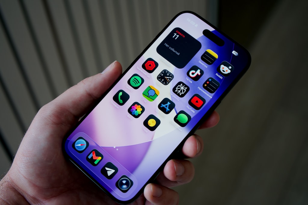 Novidades de IA no Android Drop de setembro 2026 Mão segurando smartphone com ícones de aplicativos coloridos na tela